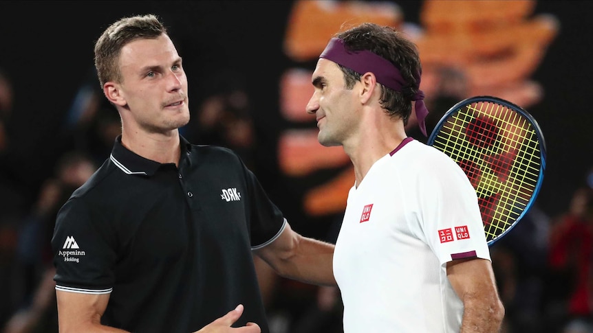 Roger Federer gets a pat on the back from Marton Fucsovics after winning a tennis match