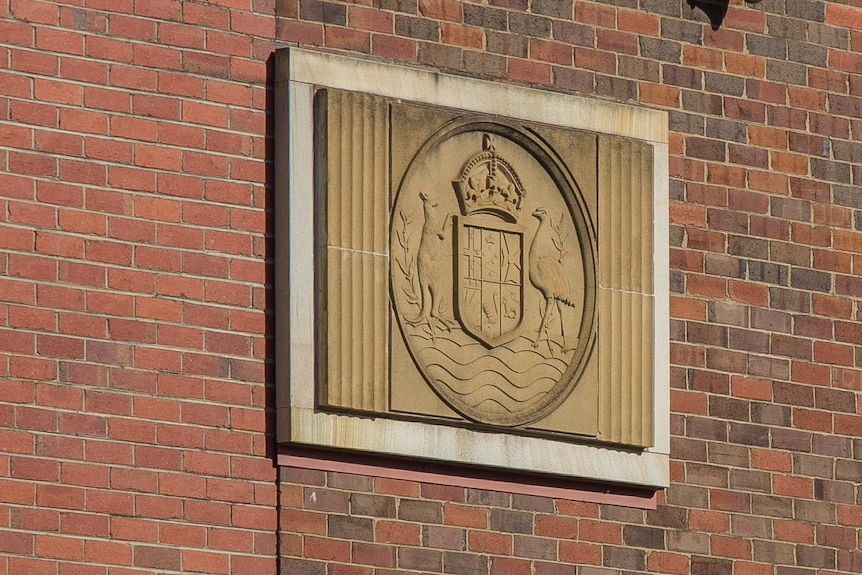Australian coat of arms on a brick wall