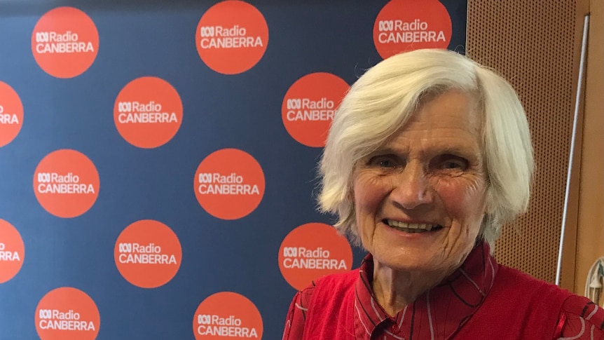woman stands in front of ABC Radio Canberra sign 
