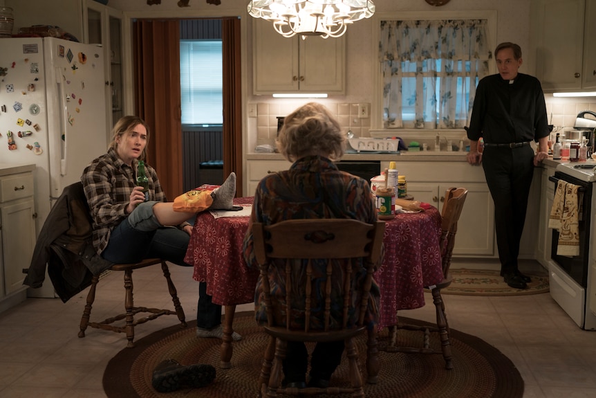 Kate Winslet, Jean Smart and Neal Huff in a suburban kitchen in tv series Mare of Easttown