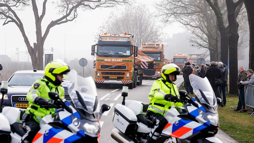 Trucks carry wreckage from Malaysia Airlines flight MH17 into the Netherlands