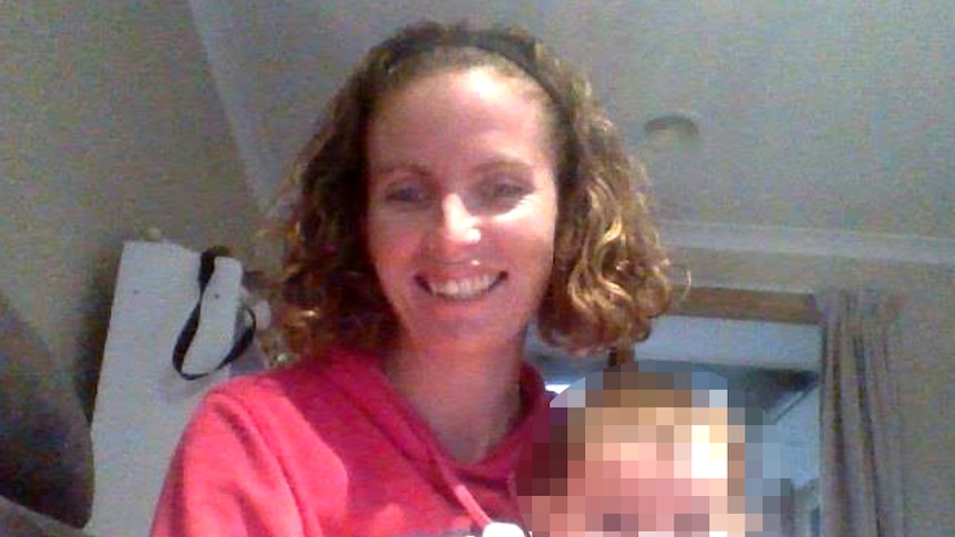 Amanda Harris is pictured holding a baby whose face has been blurred.