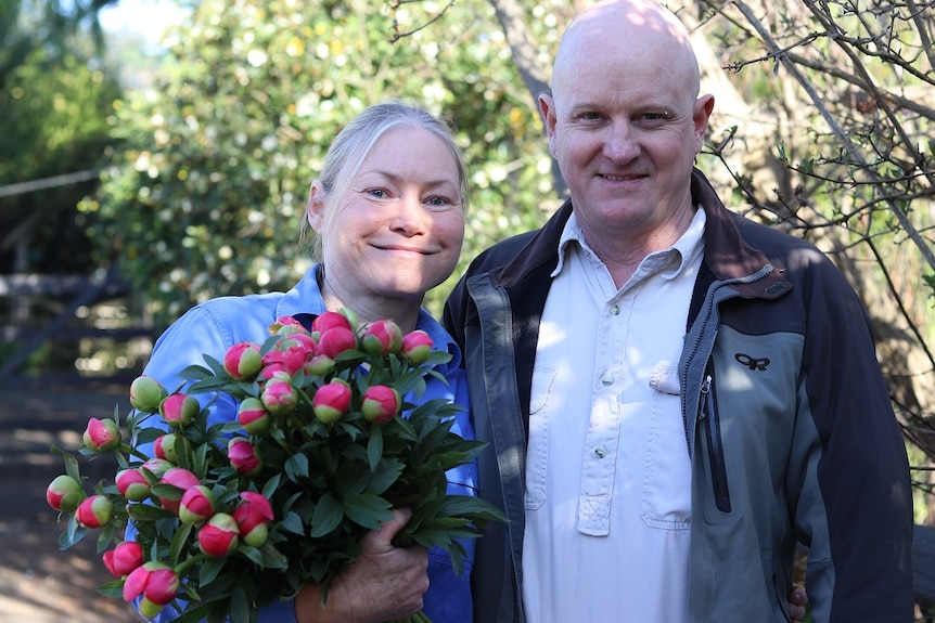 Tanya and Mark Beech holding a bunch of freshly picked peonies.