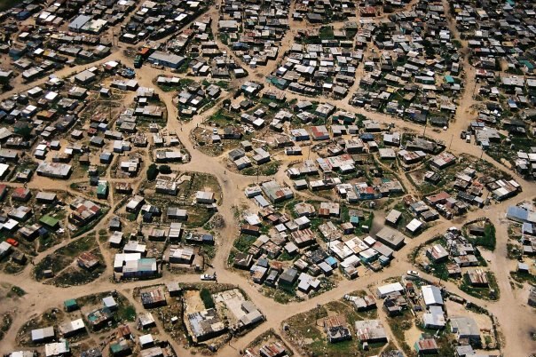 An aerial view of an informal settlement in Cape Town shows densely packed shacks.