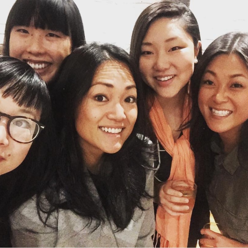 Ra Chapman is surrounded by a group of smiling women, all Korean-Australian adoptees