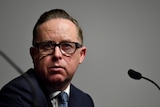 Alan Joyce glances to the side during a media conference.