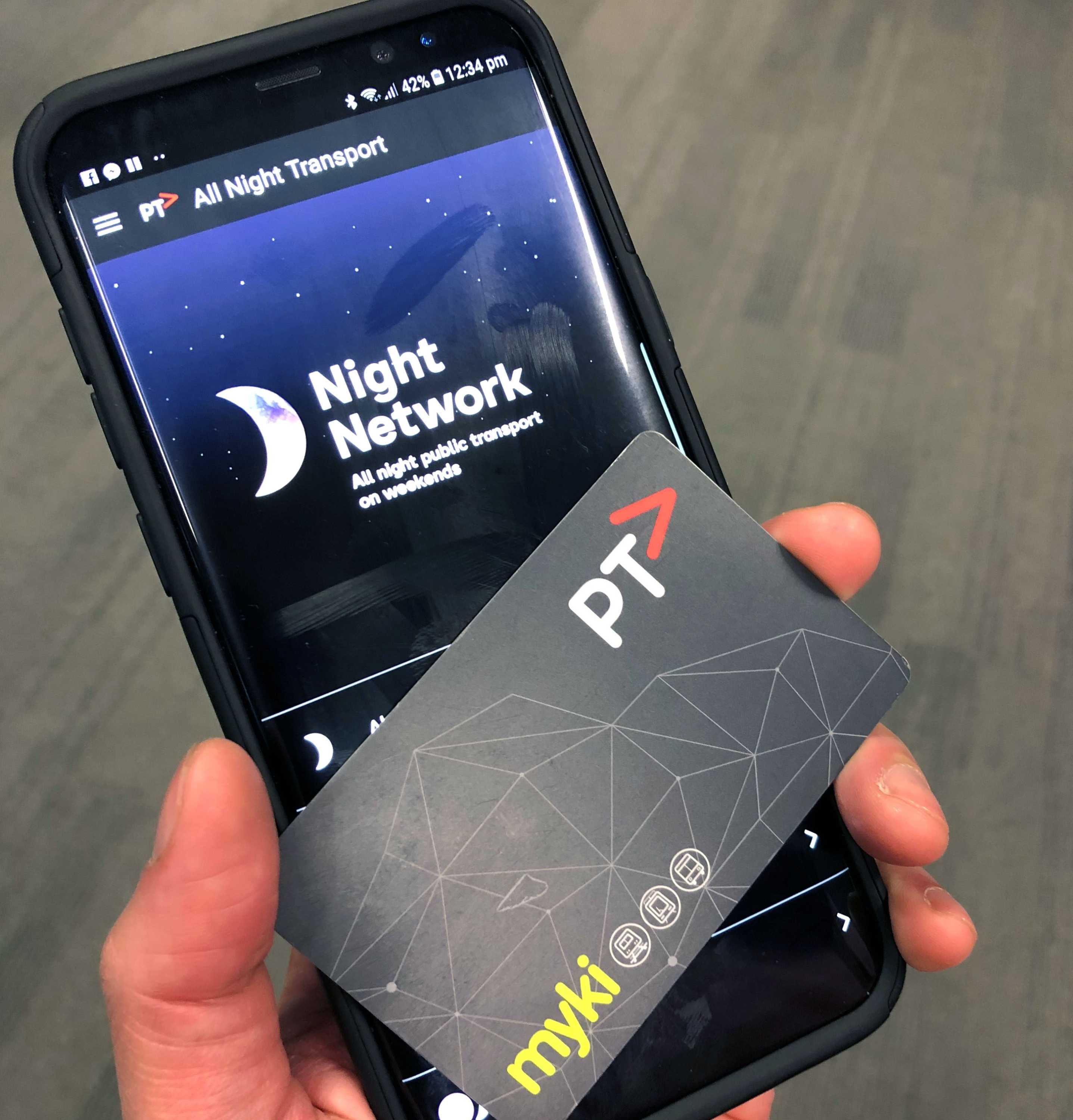 An带有夜间网络标志和 PTV myki 卡的 Android 手机。” class=
