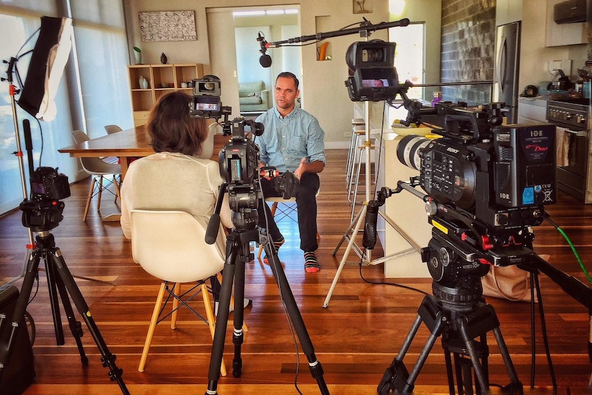 Three cameras filming producer interviewing Allan Clarke in a dining room.