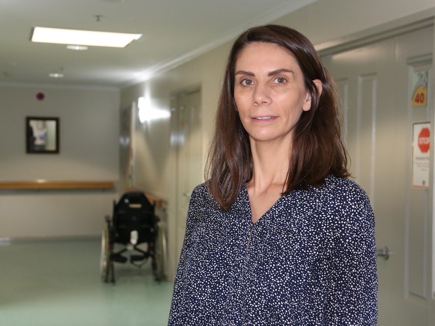 Melanie Calvert smiles in a corridor.