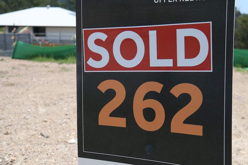 Sold sign on vacant land lot at housing estate.