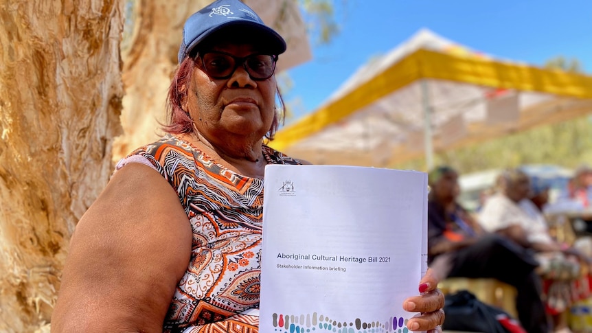 An aboriginal woman holding a paper copy of the Aboriginal Cultural Heritage Bill 