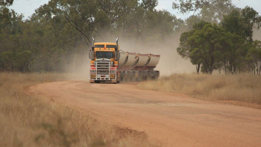 A transport truck drives along the unsealed Hann Highway.