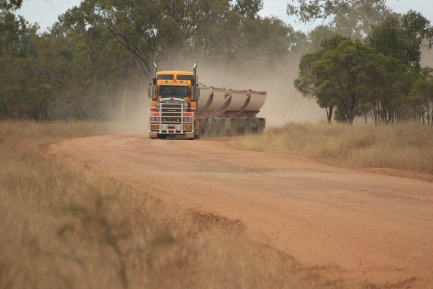 Truck driving along the unsealed Hann Highway.