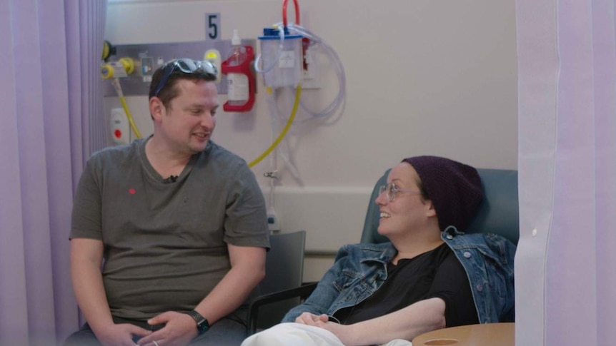 Couple in a hospital sitting on chairs looking at each other