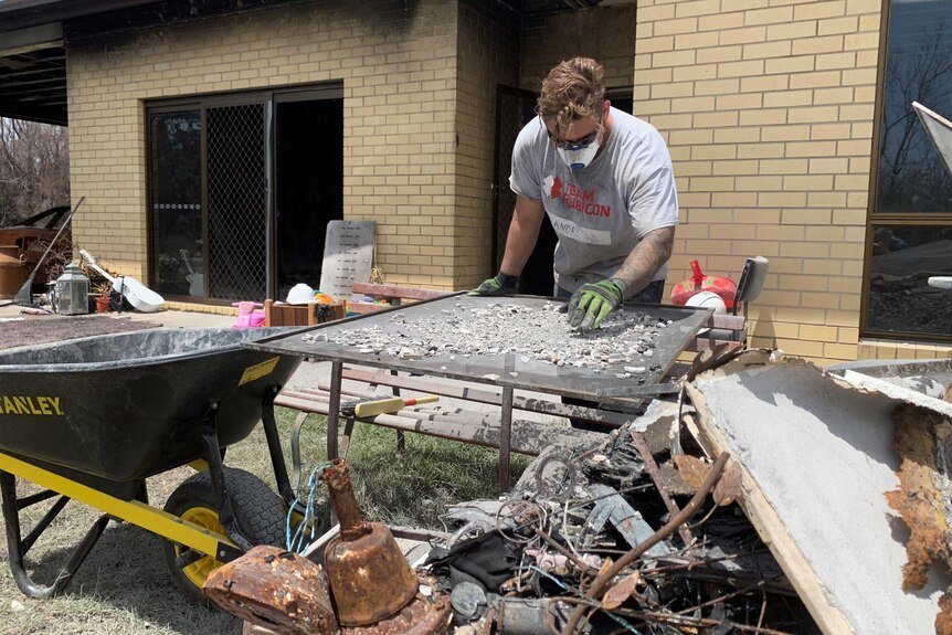 Man searches through rubble for heirlooms damaged by bushfire