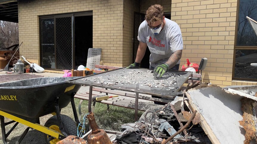 Man searches through rubble for heirlooms damaged by bushfire
