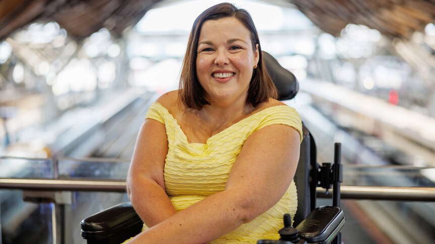 Peta Hooke sits in wheelchair and smiles at the camera 