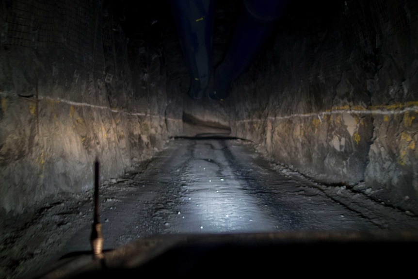 a photo from inside a car looking down a tunnel in a mine.