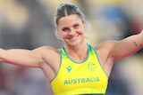 Australian pole vaulter Nina Kennedy holds her arms out in a shrug after winning Commonwealth Games gold.