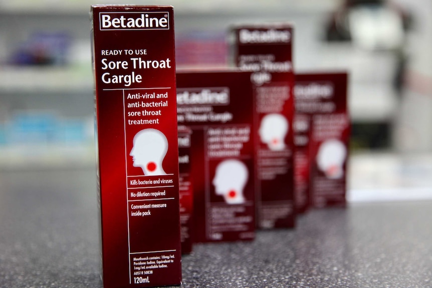 Boxes of Betadine sore throat gargle lined up on a counter.