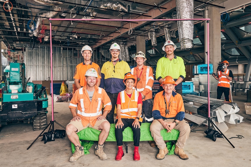 Construction workers pose for a photograph on a work site.