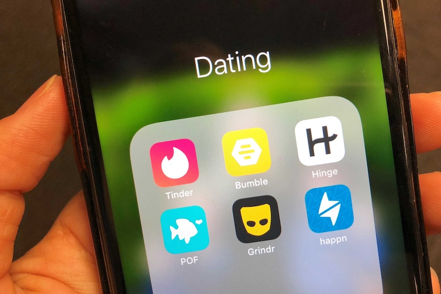 A close up photo of a phone with dating apps like Tinder, Grindr and Bumble on the screen.