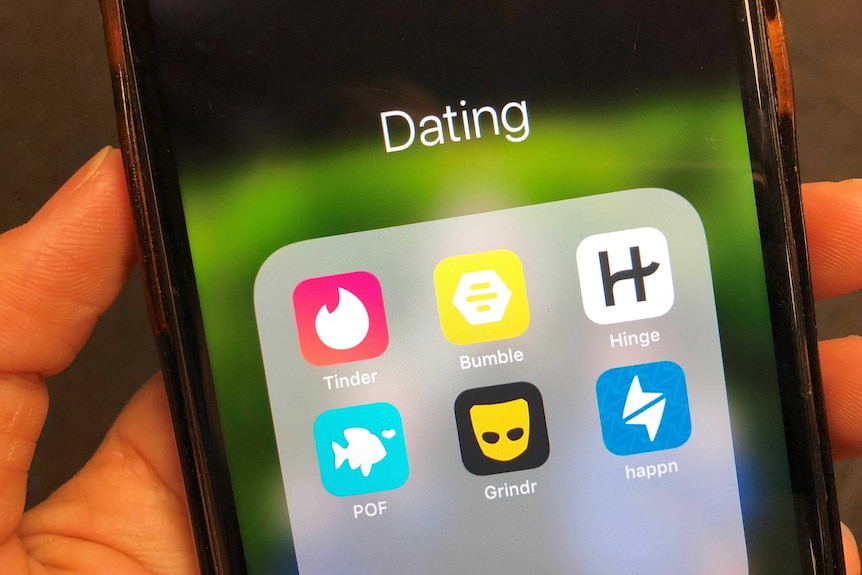 Une photo en gros plan d'un téléphone avec des applications de rencontres comme Tinder, Grindr et Bumble à l'écran.