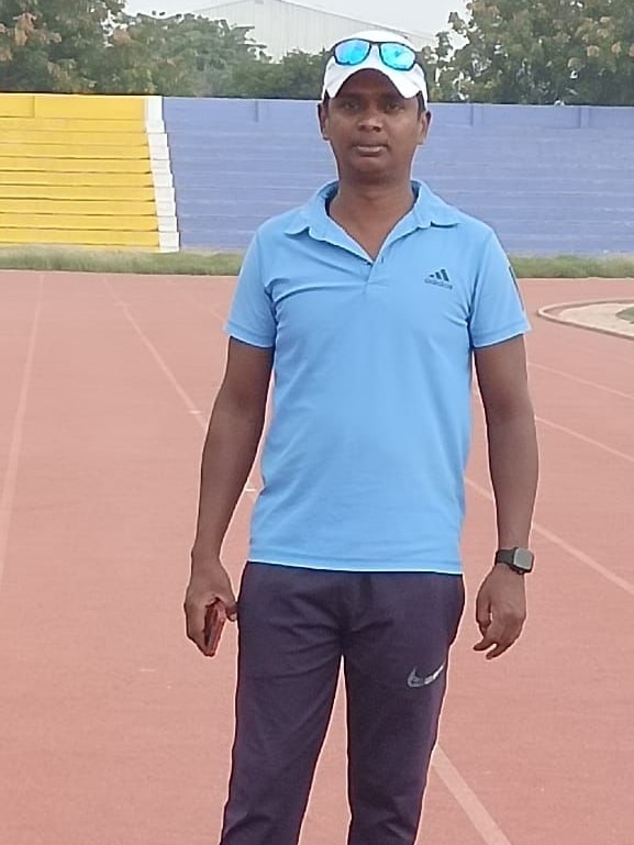 Santhi Soundarajan stands on a running track in tracksuit pants, a t-shirt and runners.