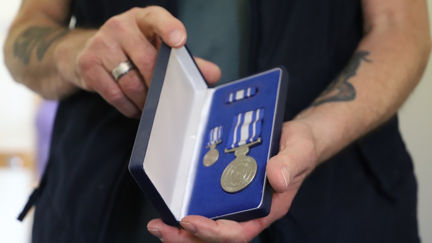 A police medal in someone's hands.