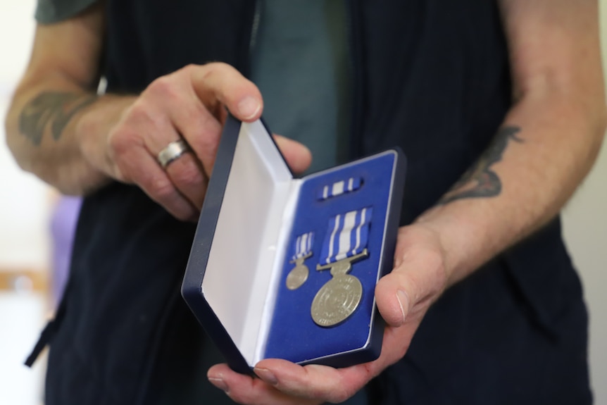 A police medal in someone's hands.