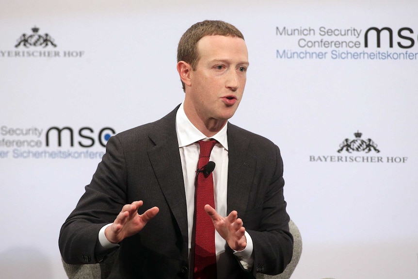 Mark Zuckerberg gestures with his hands while speaking on stage at a conference.