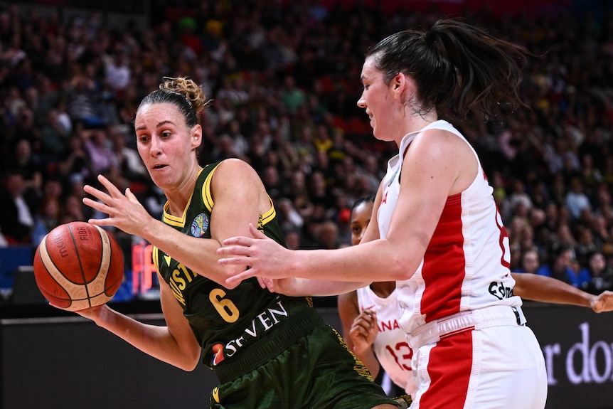 Steph Talbot holds the basketball, trying to get away from a Canadian defender