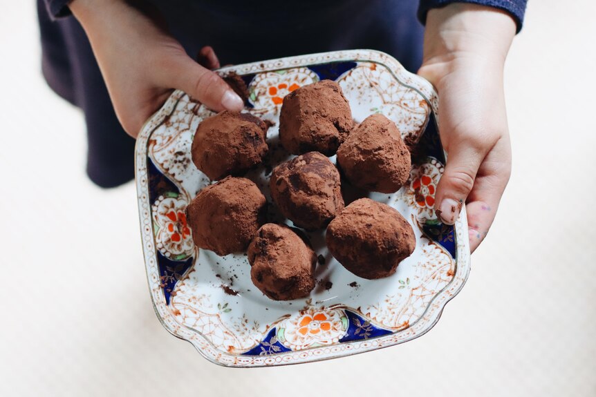 Balls of chocolate truffles on a dish.
