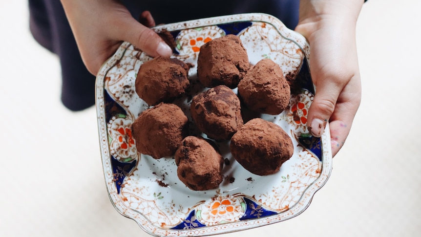 Balls of chocolate truffles on a dish.