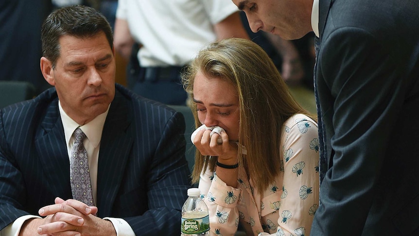 Michelle Carter cries into a handkerchief while surrounded by her defence attorneys.