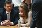 Michelle Carter cries into a handkerchief while surrounded by her defence attorneys.