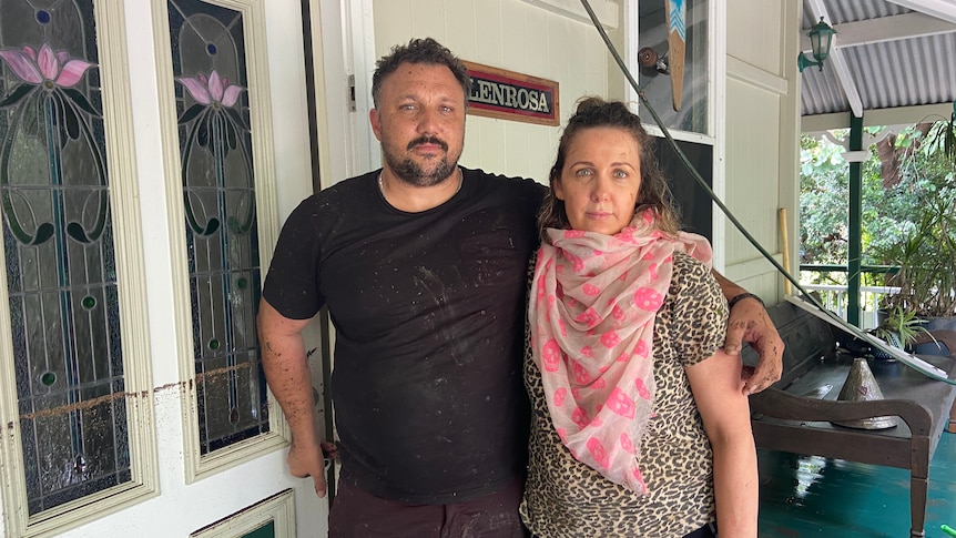 Karen and Dylan stand side by side in front of their home.