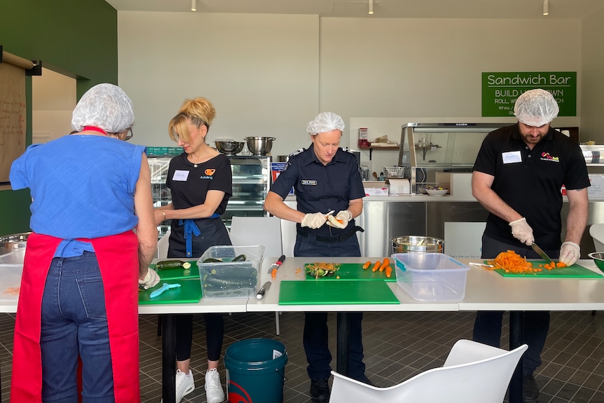 Production line of volunteers chop carrots