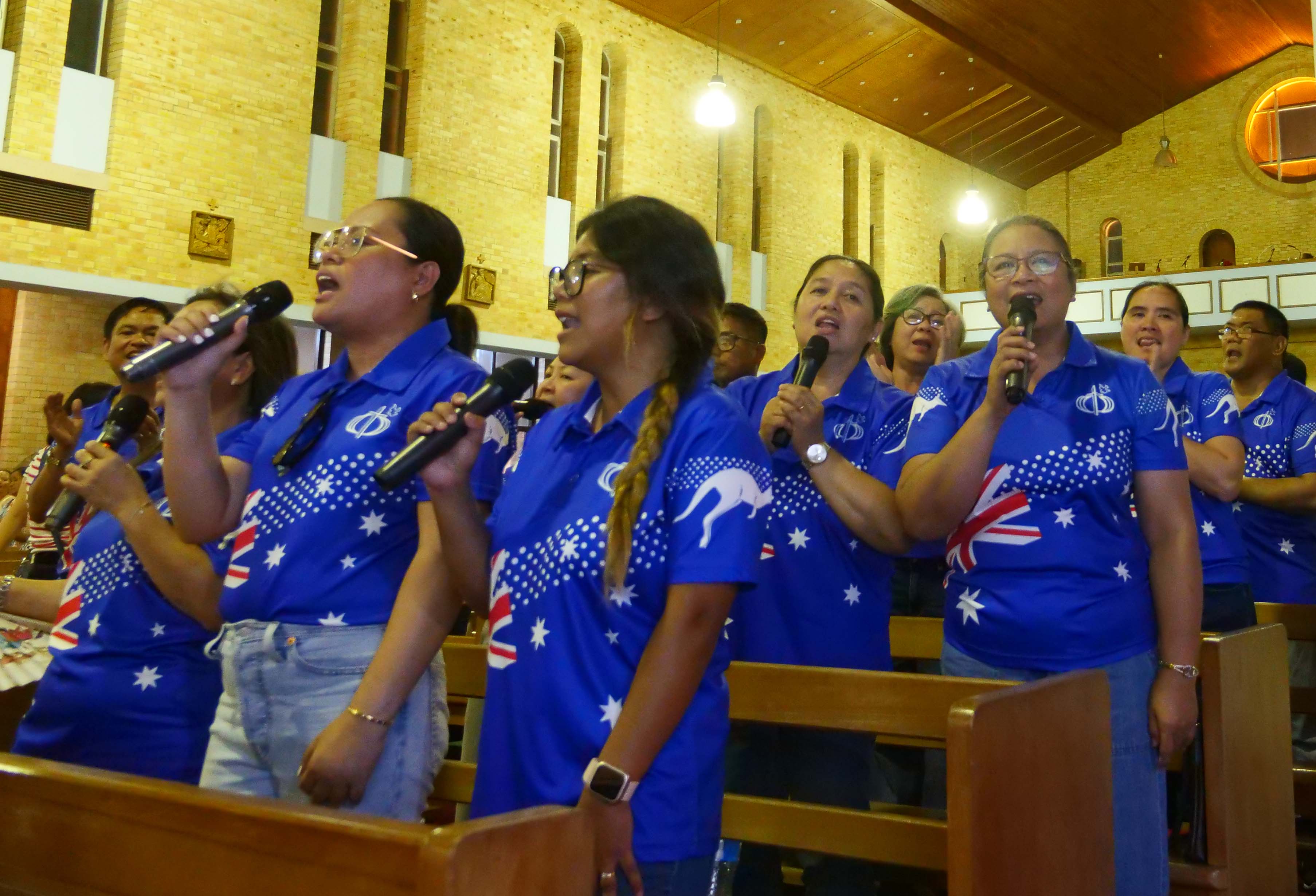 Um grupo de coral canta junto durante o evento Simbang Gabi de Mackay. 