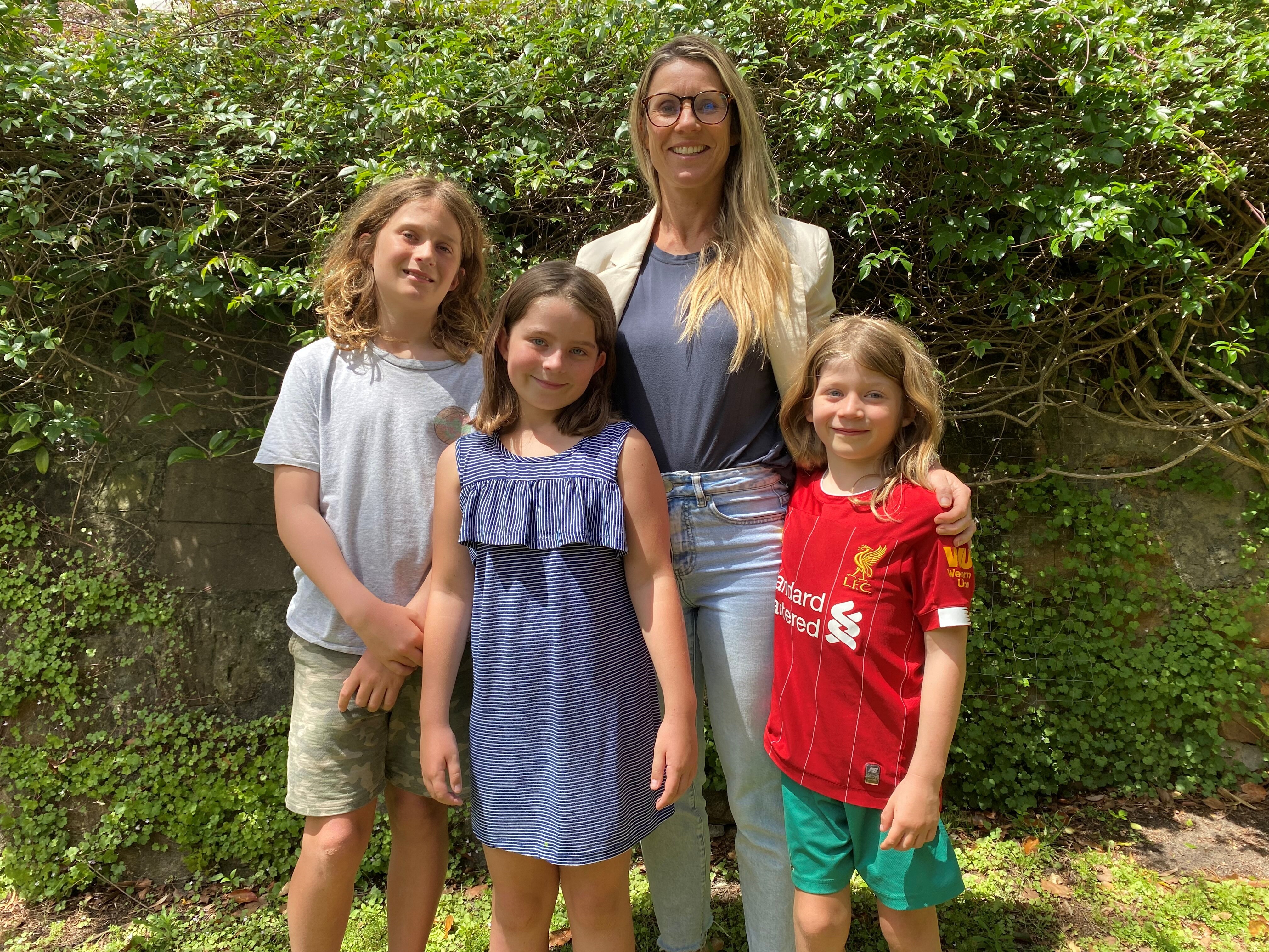 Woman standing with her three children in a garden