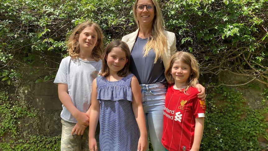 Woman standing with her three children in a garden