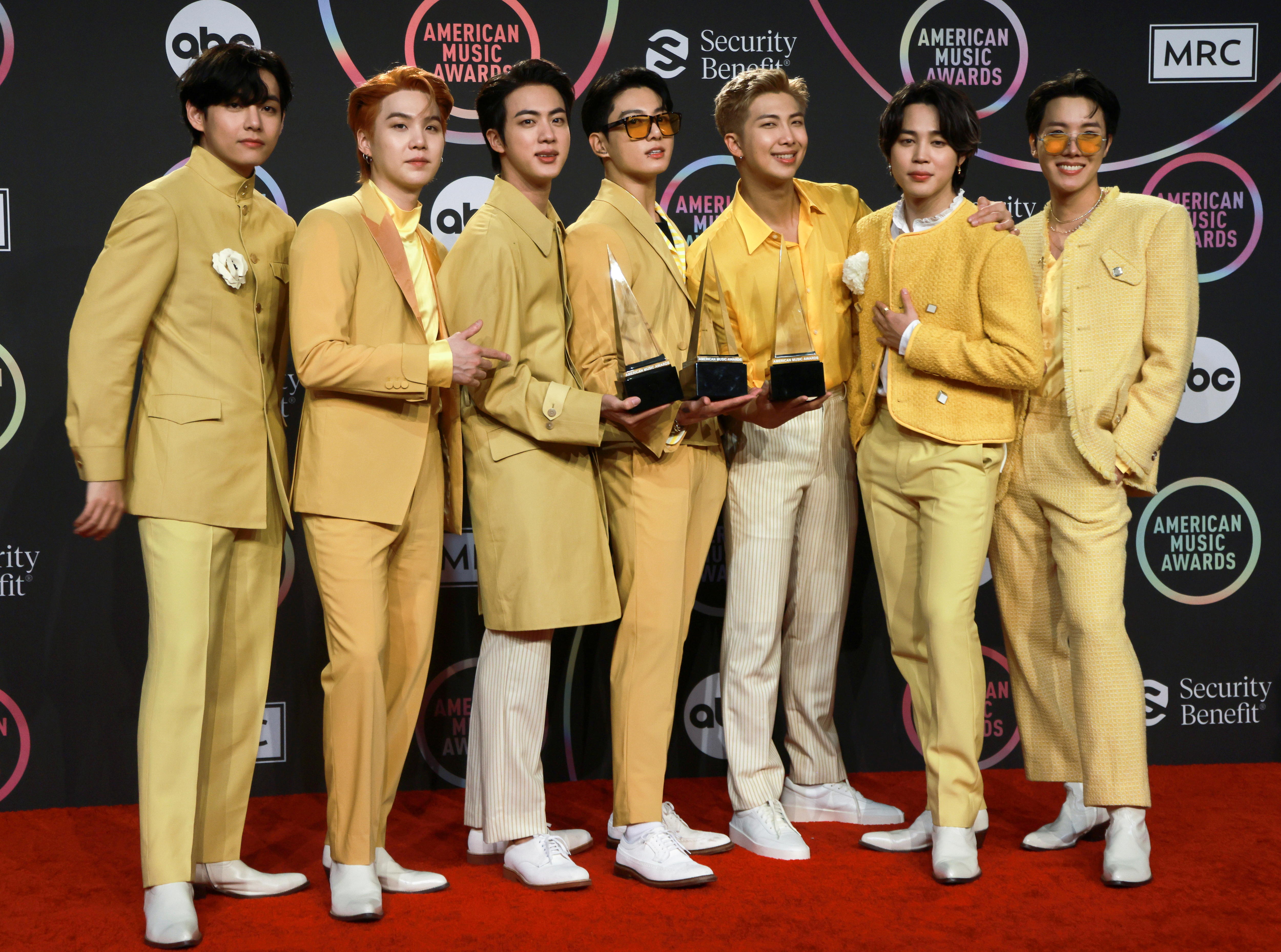 Los siete integrantes de BTS visten trajes amarillos y son ganadores de tres American Music Awards