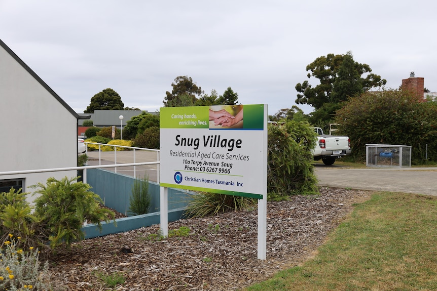 The front of and aged care facility with a sign that reads 'Snug Village Residential Aged Care Services'