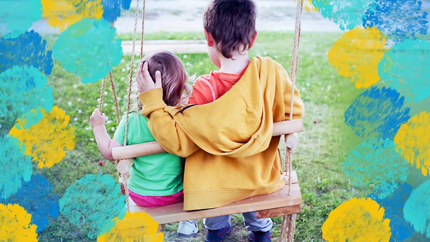 Two young children sit on a swing together, the eldest protectively holding the younger to depict raising kind kids.