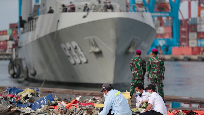 Investigators inspect pieces of the Sriwijaya Air flight SJ-182 retrieved from the Java Sea where the passenger jet crashed.