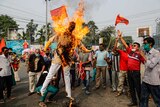 Supporters of leftist parties burn an effigy of Indian Prime Minister Narendra Modi