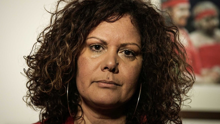 A tight headshot of Malarndirri McCarthy shows her with a plain expression on her face. She is wearing hoop earrings.