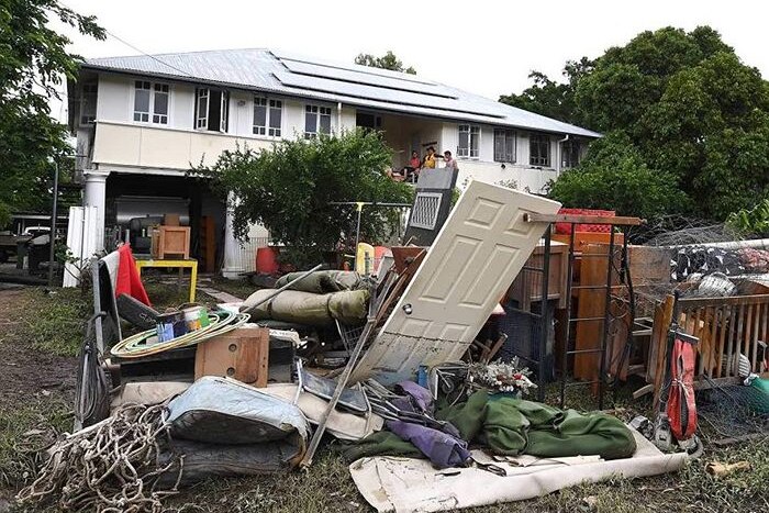 Townsville residents pile up water-damaged possessions as floods waters recede.
