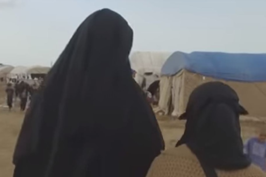 Women in burkas walk through al-Hawl, the sprawling refugee camp in Syria's Kurdish north-east.