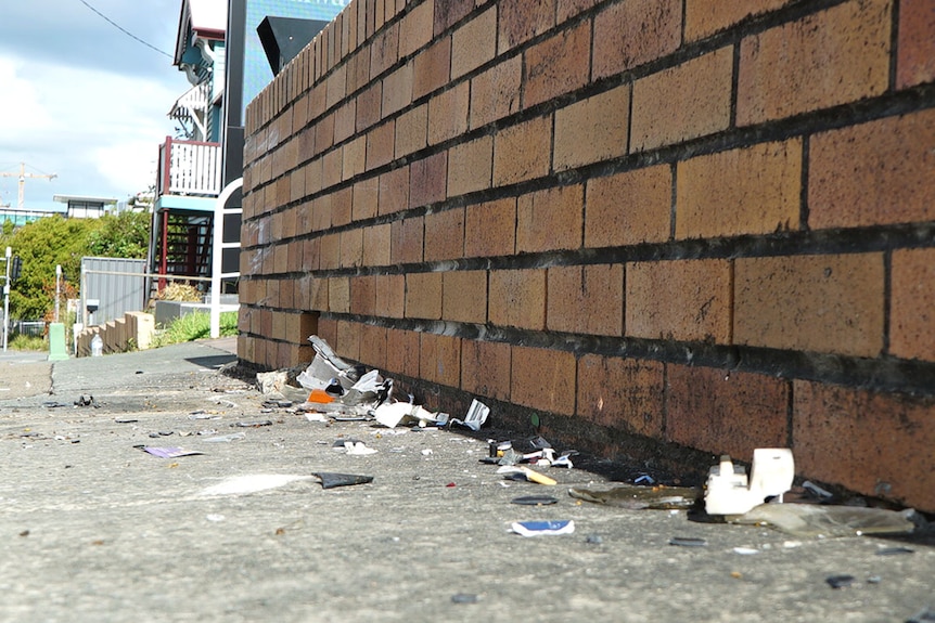 Crash debris at the foot of a short brick wall